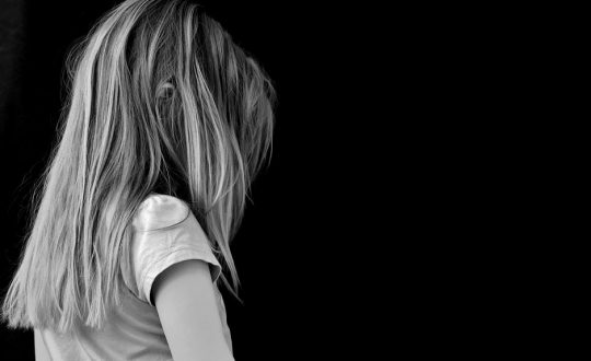 menina em preto e branco de lado com cabelo no rosto