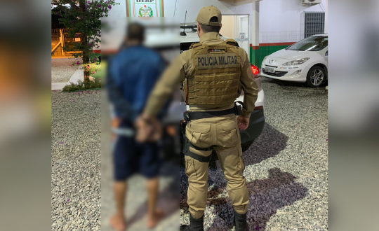 PM segura homem algemado, os dois de costas para a foto