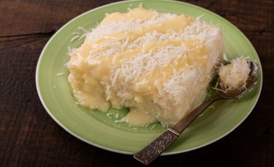 Bolo de tapioca com leite condensado e coco em prato verde