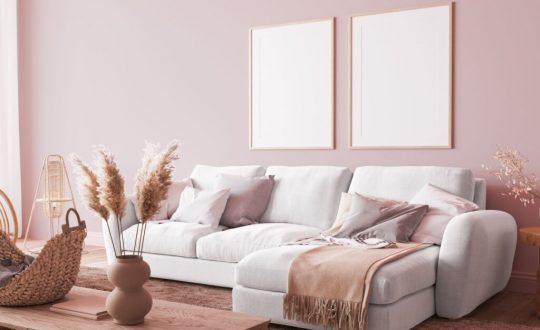 Sala de estar com sofá branco e parede rosa