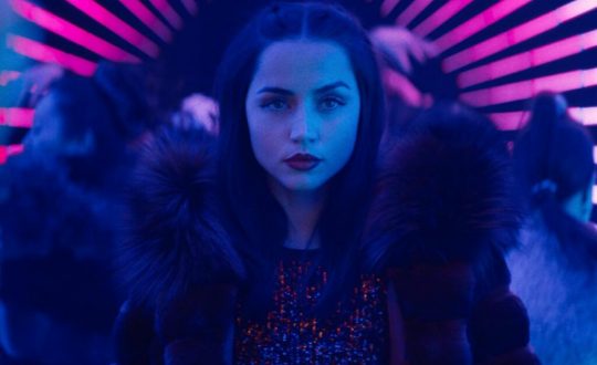 Ana de Armas em um ambiente com luzes neon no filme