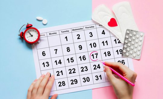 Mãos femininas preenchendo um calendário menstrual