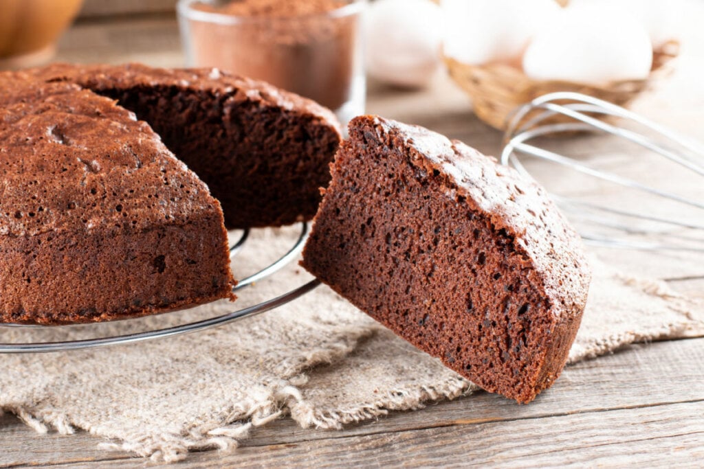 Fatia de bolo de chocolate ao lado de bolo inteiro