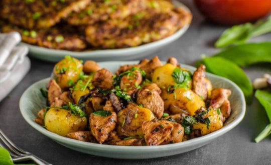 Prato branco com frango grelhado com batata e folhas de taioba