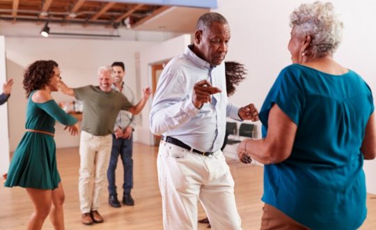 cinco pessoas felizes e dançando em uma ambiente fechado