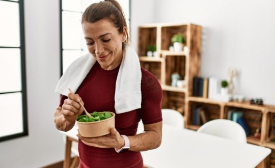 Mulher fazendo refeição saudável após o treino