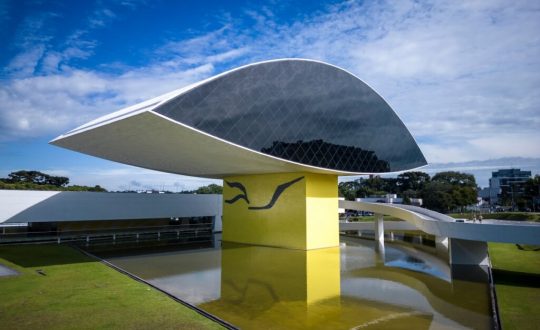 Imagem de uma construção em vidro que se assemelha a um olho humano no Museu Oscar Niemeyer em Curitiba