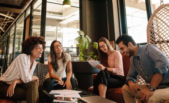 Equipe de negócios trabalhando em novo projeto e sorrindo.