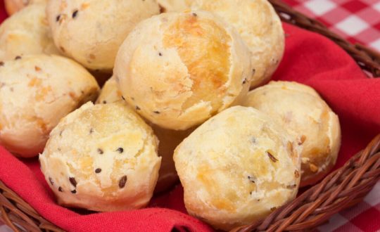 Pães de queijo com chia dentro de uma cesta com pano vermelho