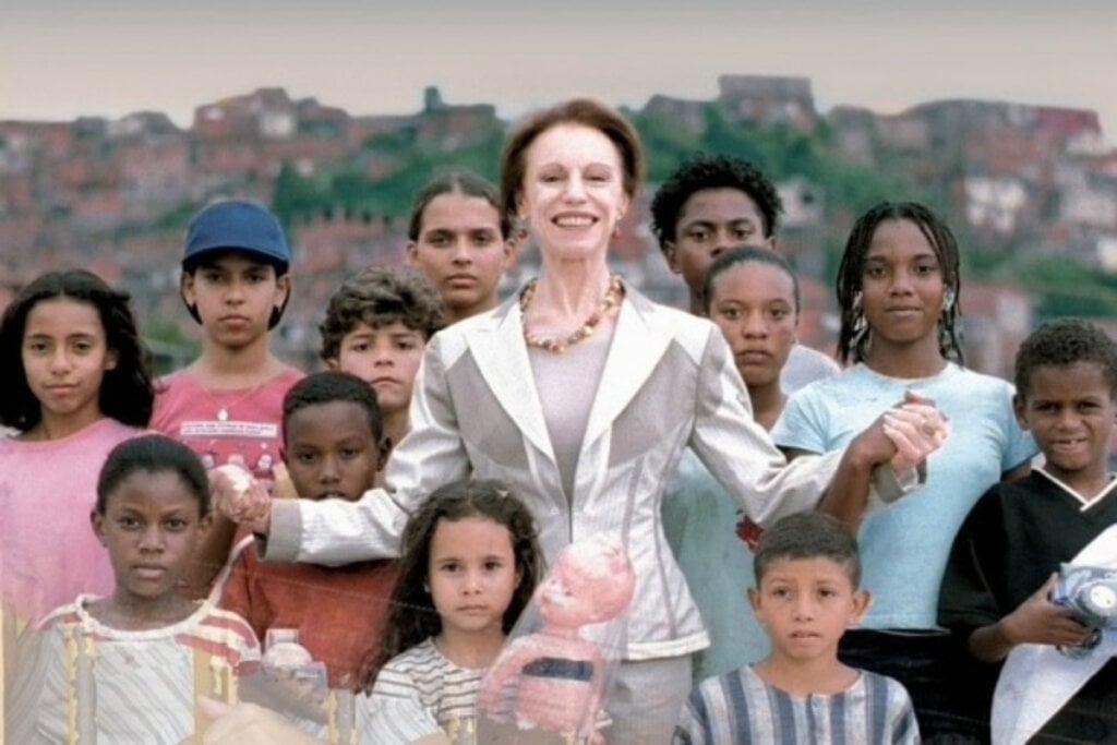 Cena do filme "Quanto Vale ou É Por Quilo?" com mulher com roupa branca no centro e crianças de diferentes tamanhos em volta