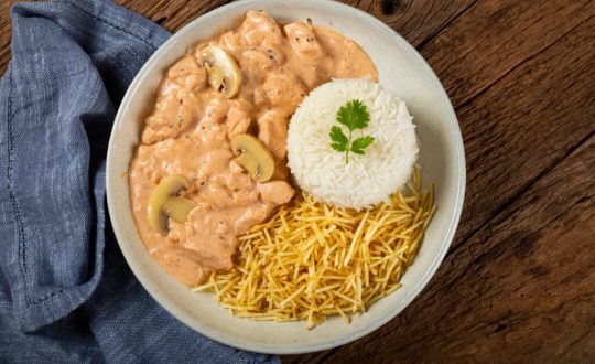 Prato branco com estrogonofe de frango, arroz e batata-palha