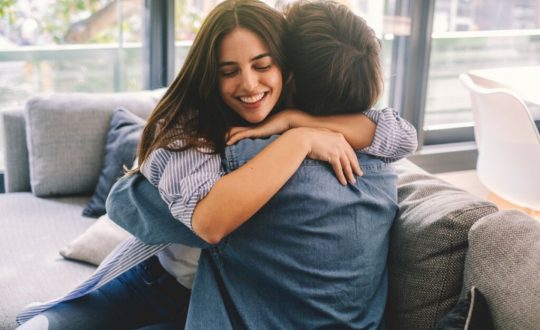 Homem e mulheres sentados em um sofá e se abraçando