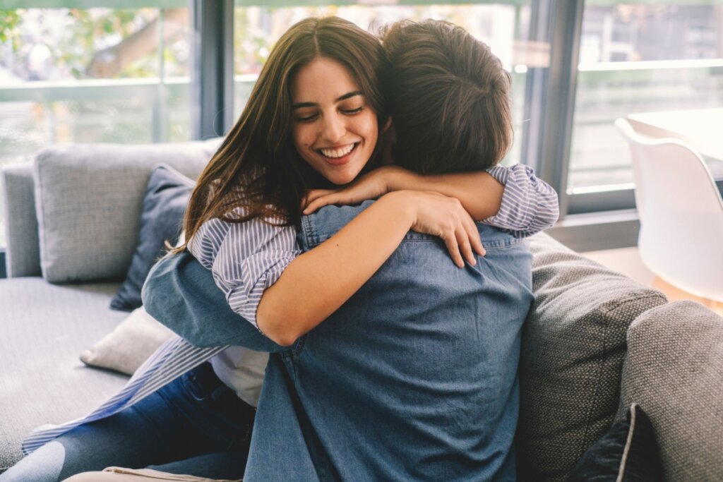 Homem e mulheres sentados em um sofá e se abraçando 